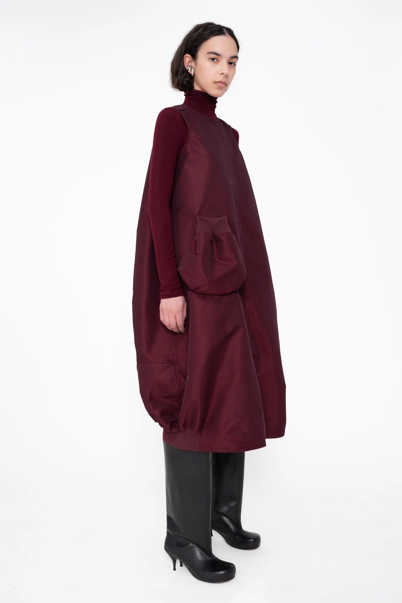 female-wearing-bordeaux-bomber-dress-with-big-front-pocket-on-white-background-full-body-three-quarter