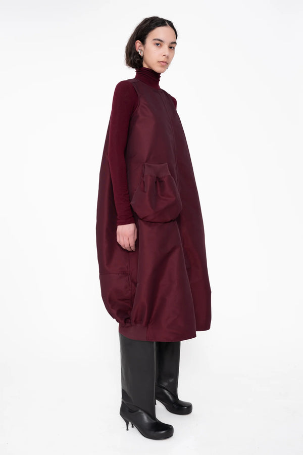 female-wearing-bordeaux-bomber-dress-with-big-front-pocket-on-white-background-full-body-three-quarter