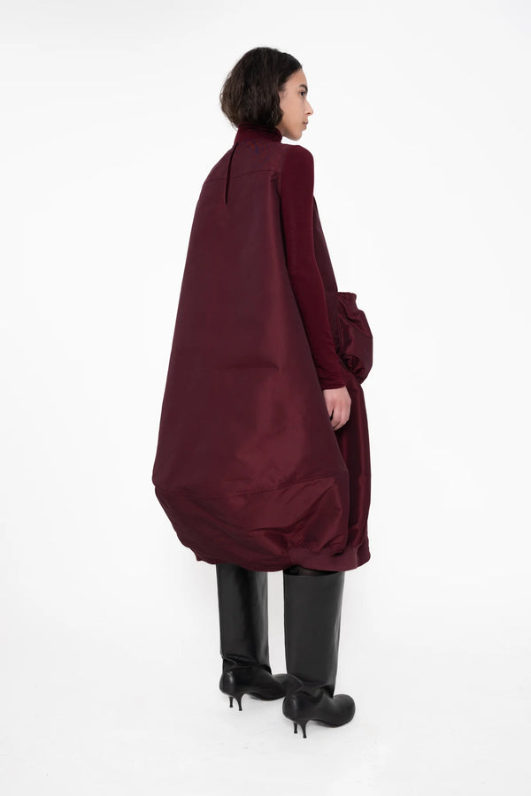 female-wearing-bordeaux-bomber-dress-with-big-front-pocket-on-white-background-full-body-one-quarter