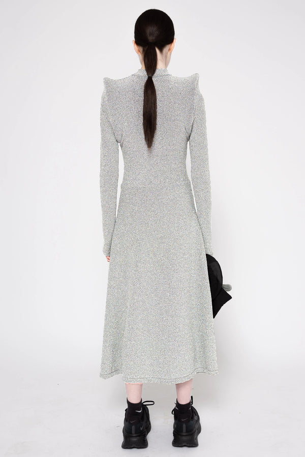 Model wearing silver column dress on a white background, back.