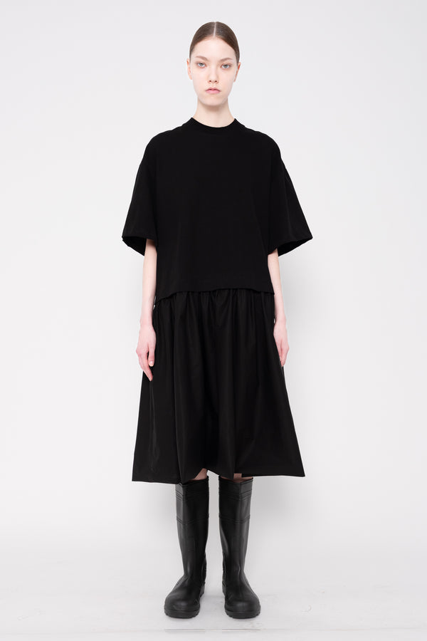 Person wearing a black outfit on a white background