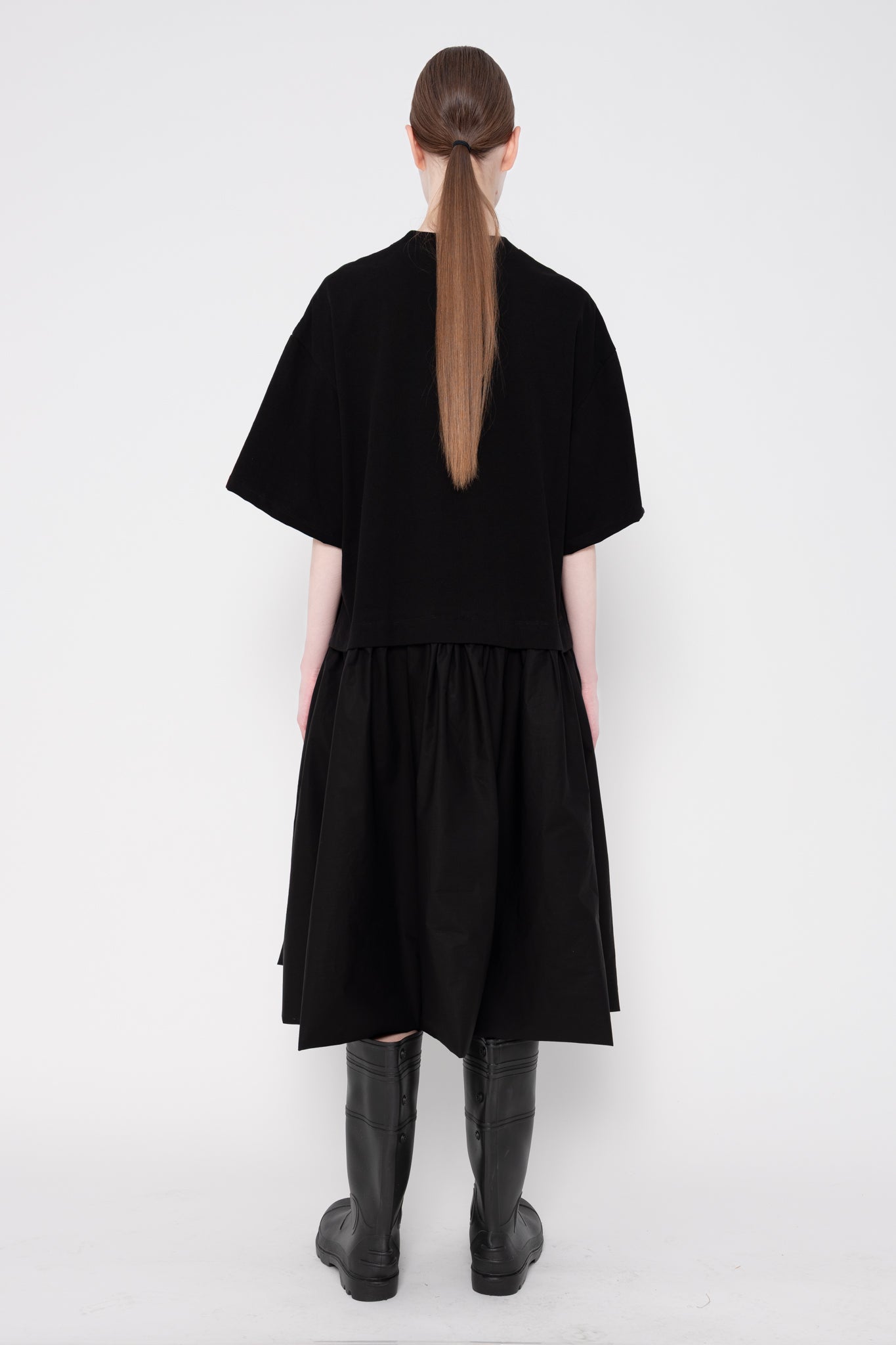 Person wearing a black dress with a plain white background