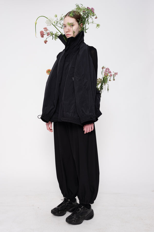 Person wearing a black outfit with flowers on a white background