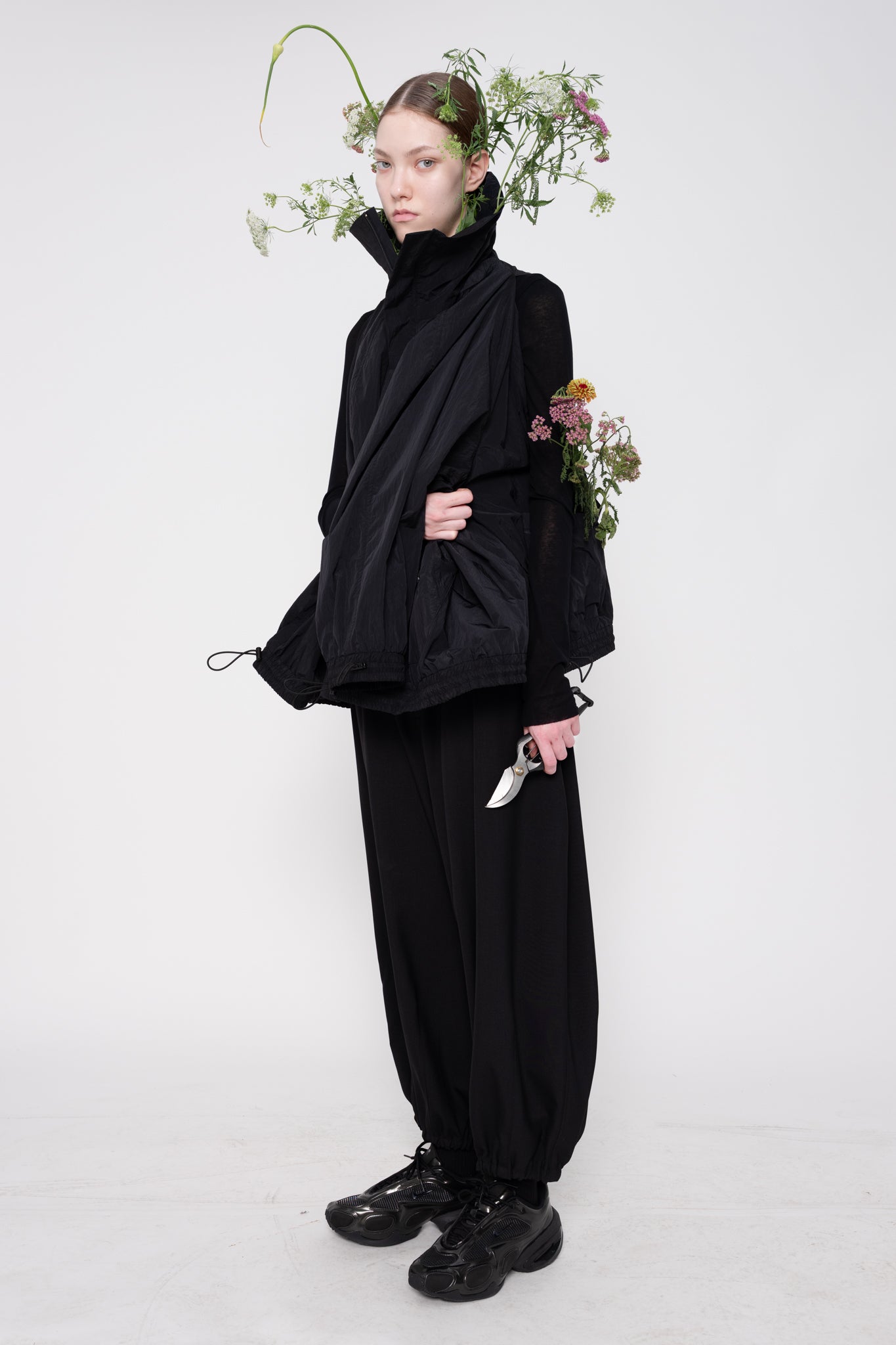 Person wearing a black outfit with a white background