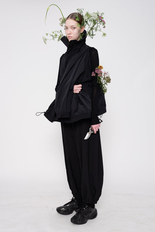 Person wearing a black outfit with a white background