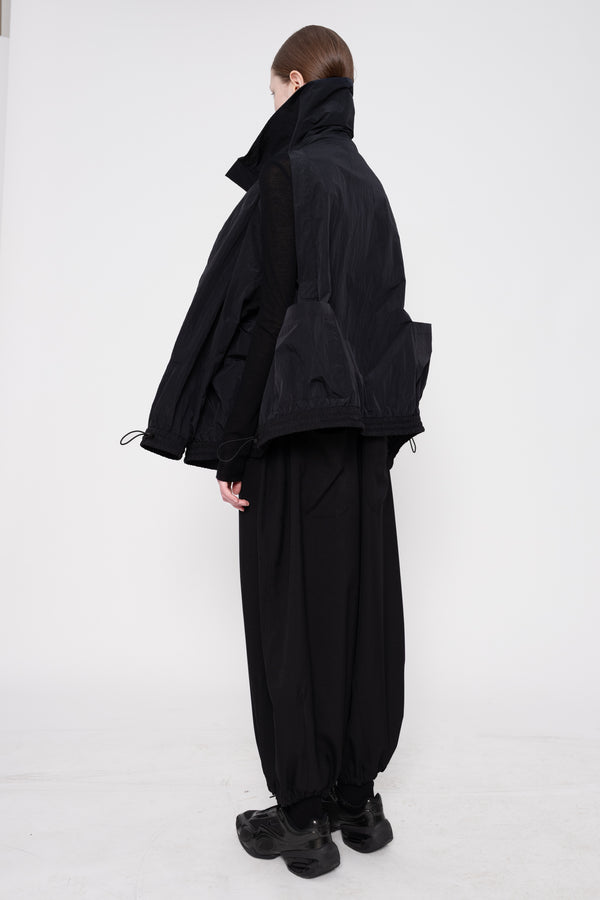 Person wearing a black outfit on a white background
