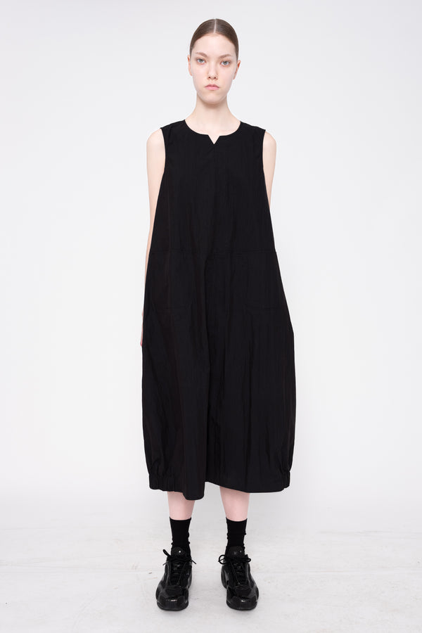 Person wearing a black sleeveless dress on a white background