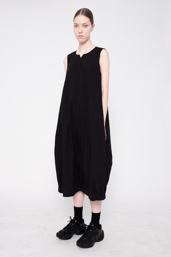 Person wearing a black sleeveless dress on a white background