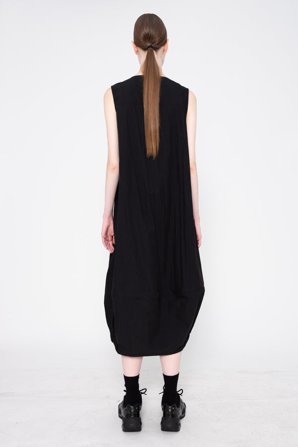 Person wearing a black sleeveless dress on a white background