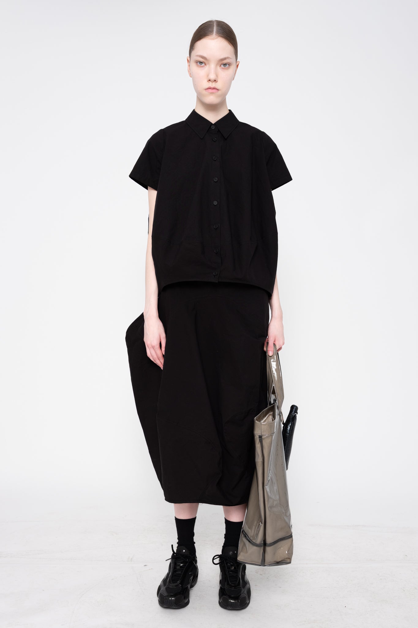 Person wearing a black outfit with a white background