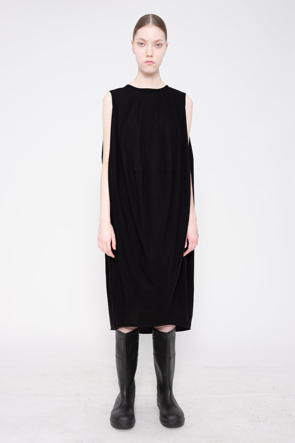 Person wearing a black sleeveless dress on a white background