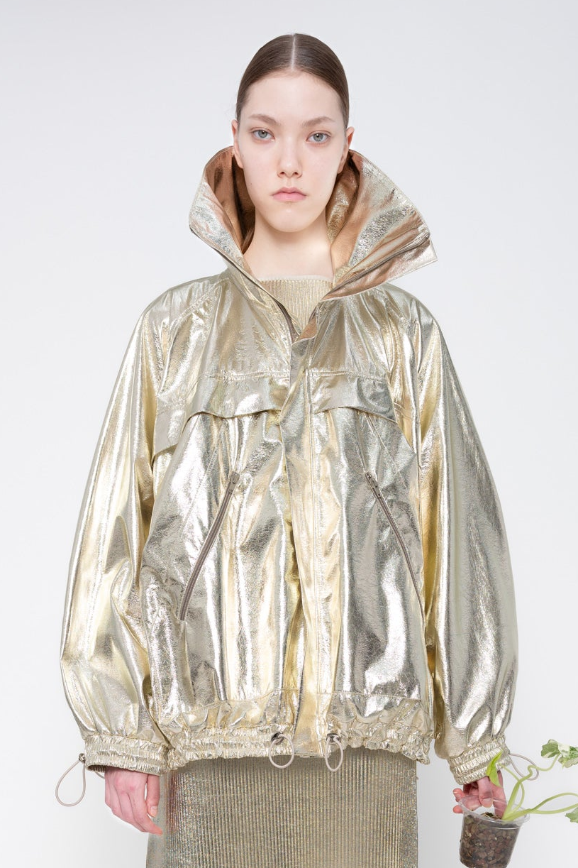 Person wearing a reflective silver jacket on a white background