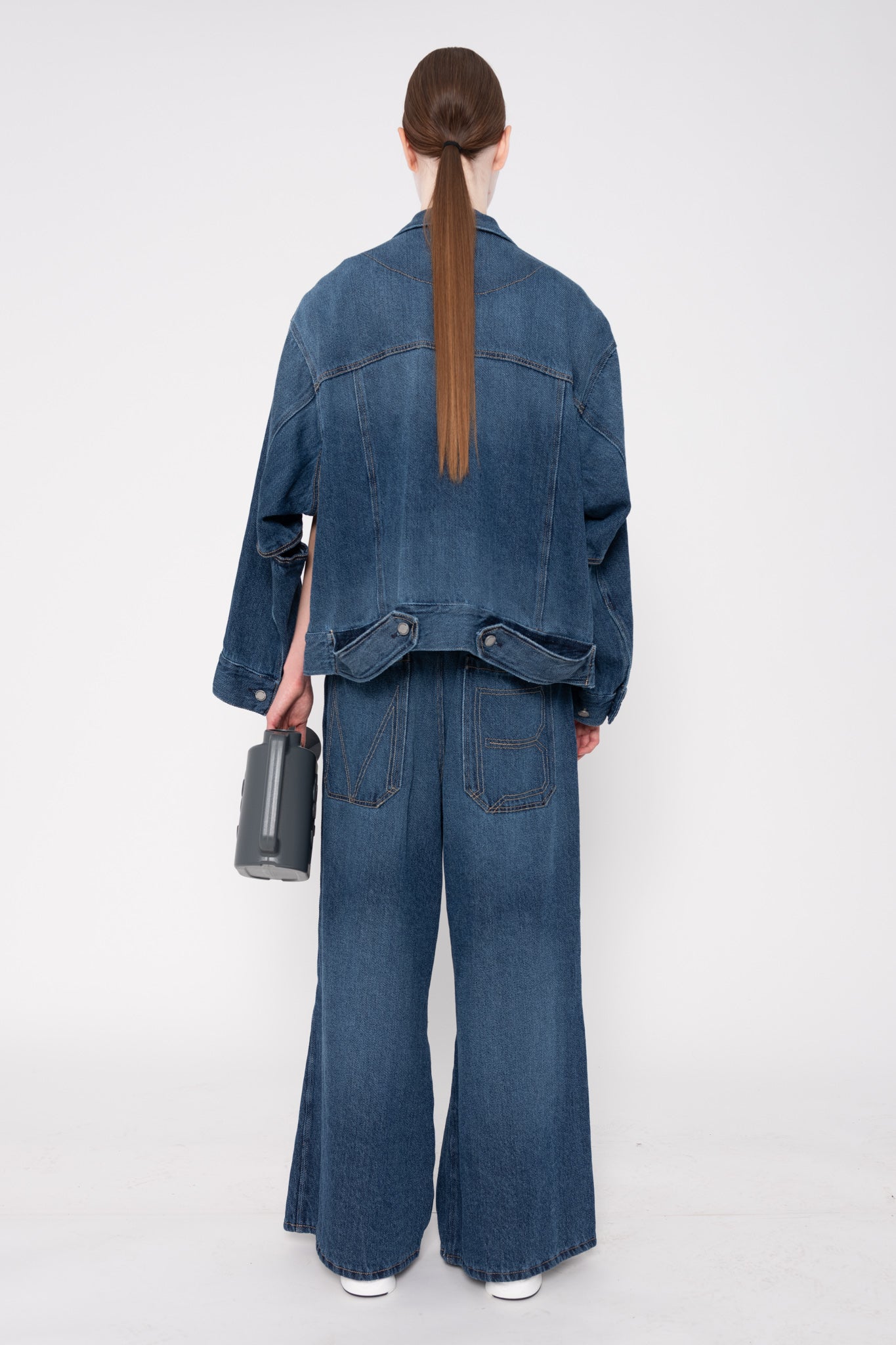 Person wearing a blue denim outfit on a white background