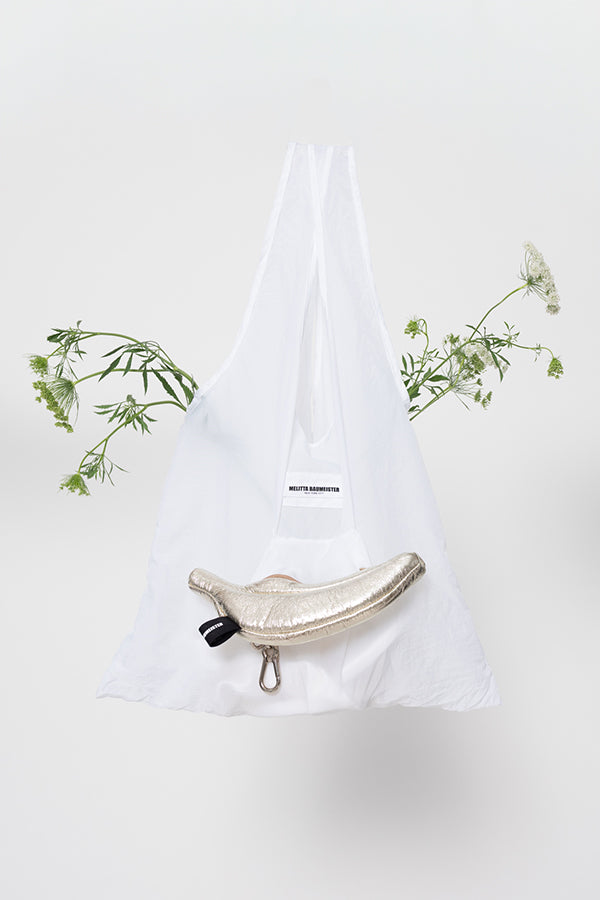 White tote bag with a decorative pouch and flowers on a light background