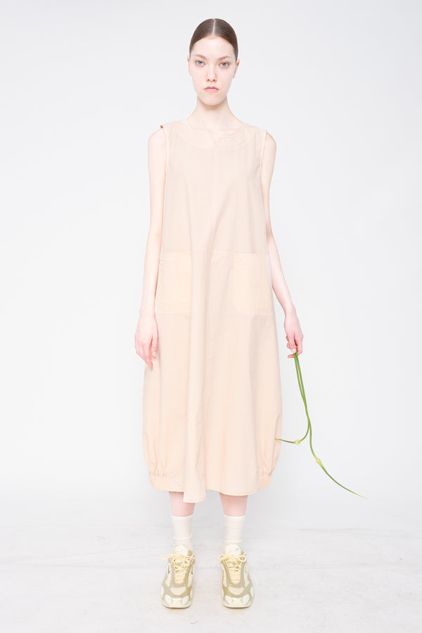 Woman wearing a beige sleeveless dress on a white background