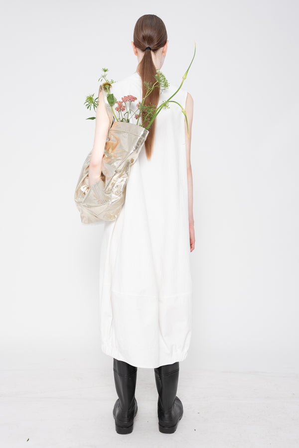Person wearing a white dress holding flowers against a white background