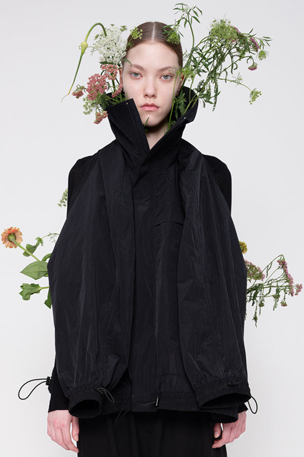 Person wearing a black outfit with floral elements on a white background