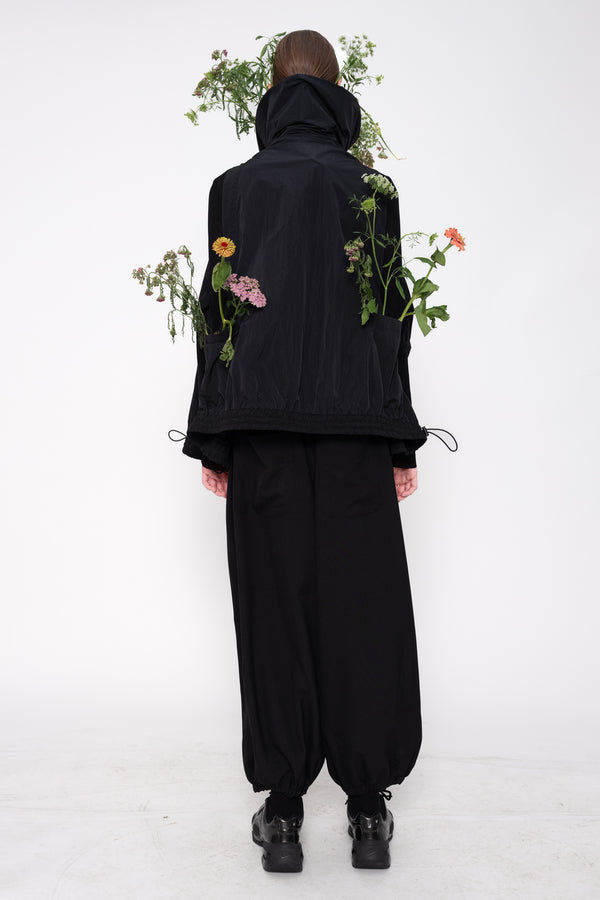 Person wearing a black outfit with floral patterns on a white background