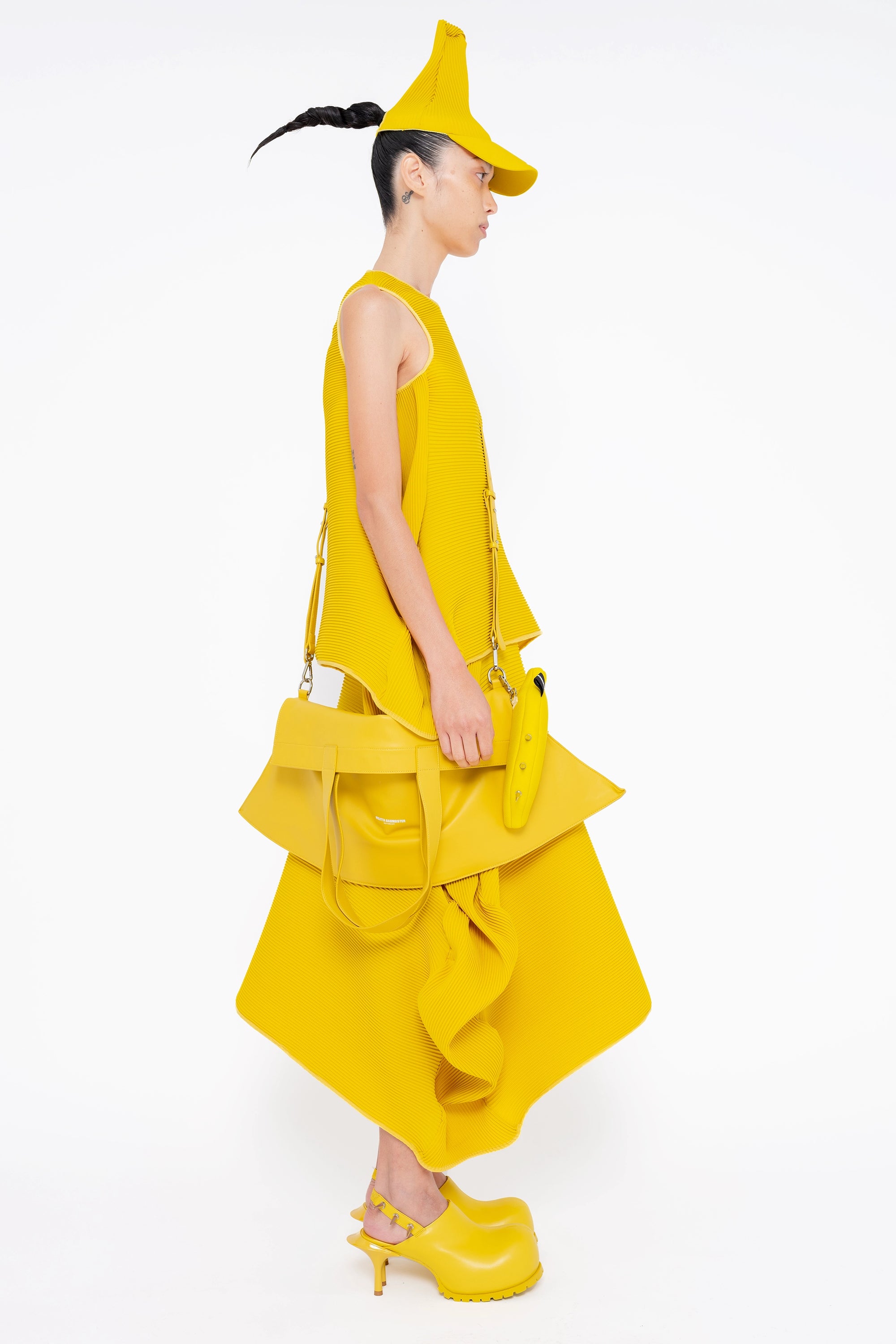 female-wearing-yellow-pleated-top-with-ruffles-and-yellow-long-pleated-skirt-with-ruffles-on-white-background-full-body-side