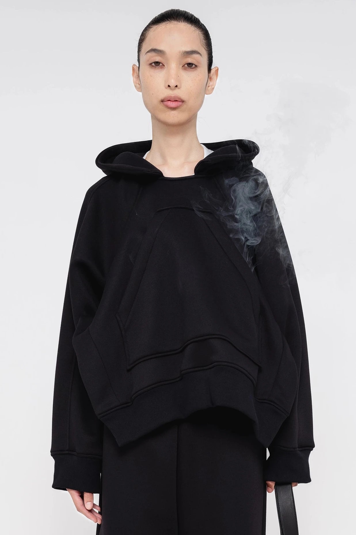 brunette-model-white-background-wearing-black-cropped-hoodie-quarter-view-front