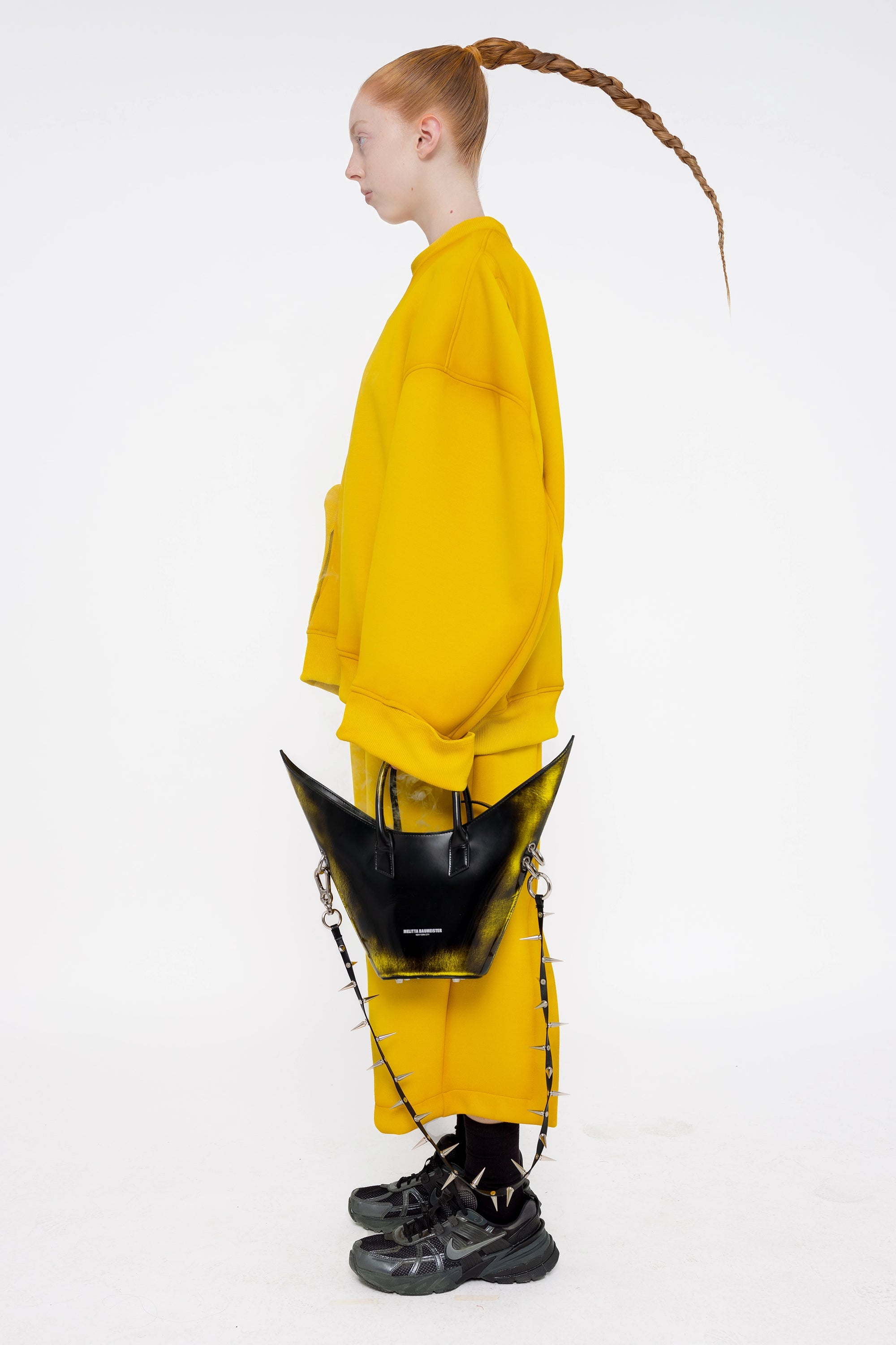 female-wearing-yellow-crewneck-sweater-and-yellow-lounge-pants-with-mustard-spray-paint-on-white-background-full-body-side