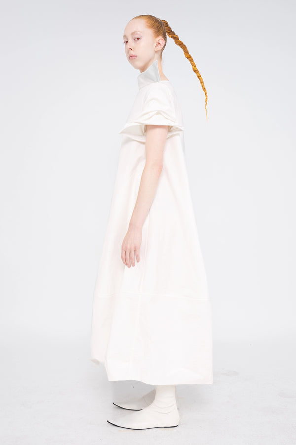 female-wearing-white-maxi-dress-with-stand-up-collar-and-short-pointy-sleeves-on-white-background-full-body-side