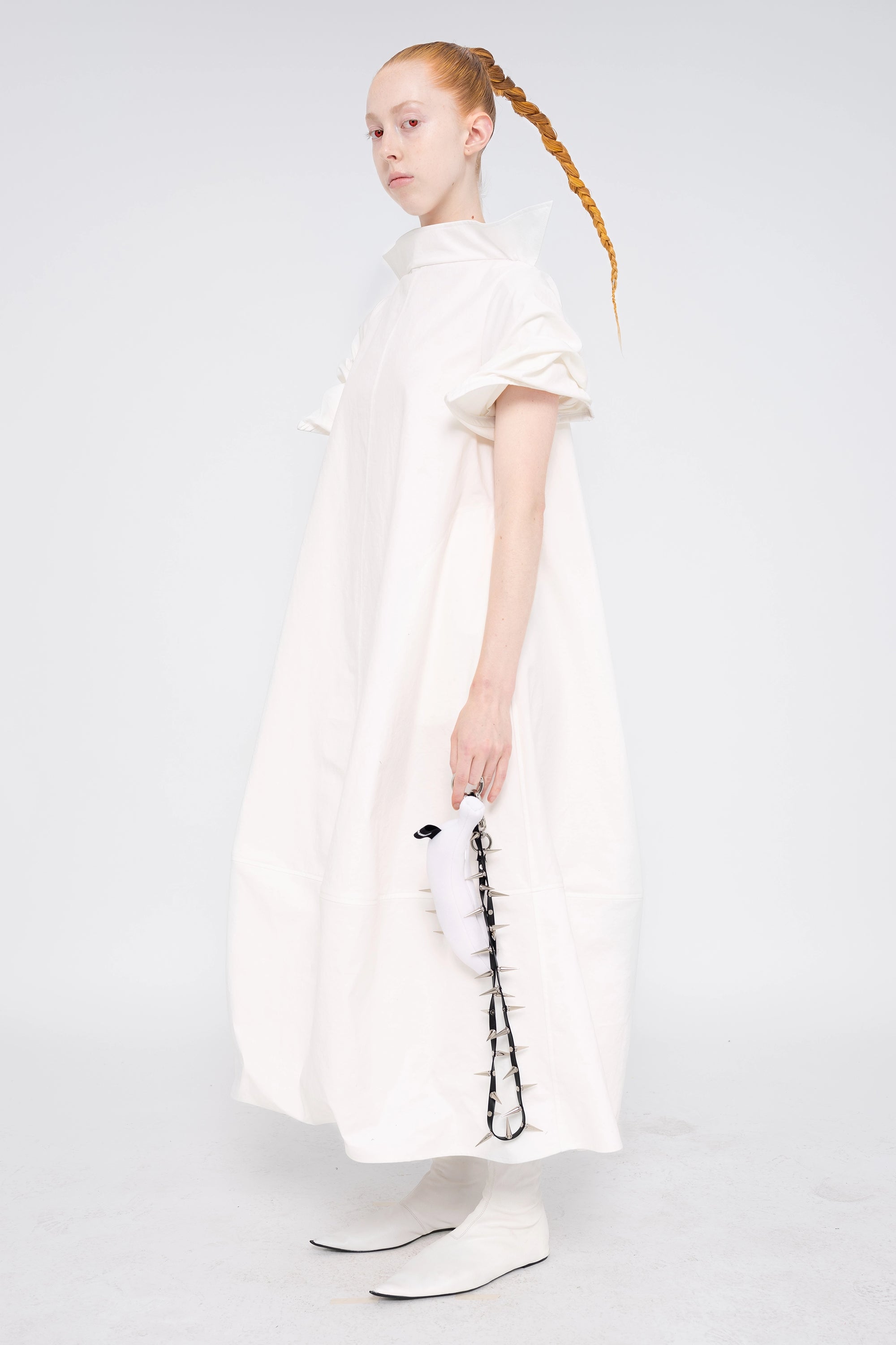 female-wearing-white-maxi-dress-with-stand-up-collar-and-short-pointy-sleeves-on-white-background-full-body-three-quarter