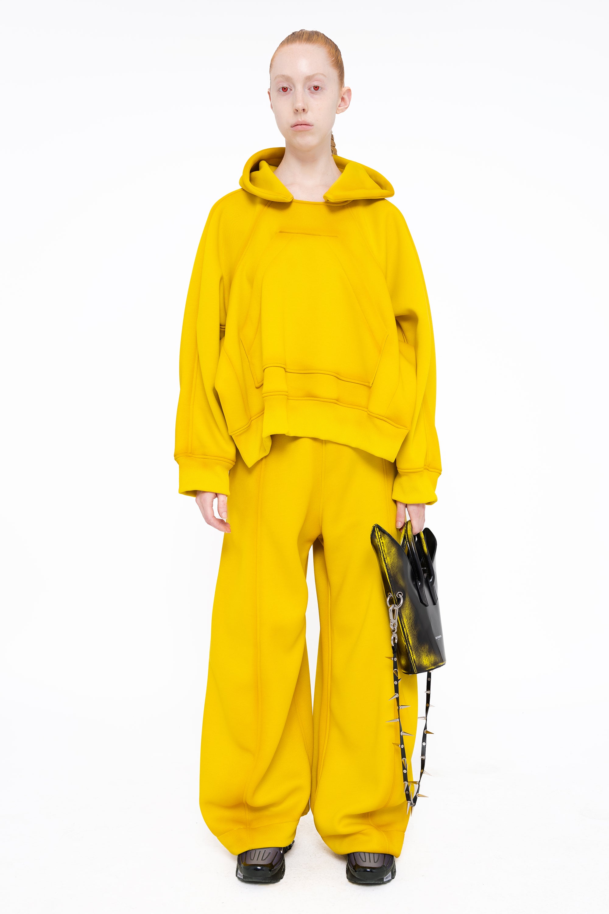 female-wearing-yellow-hoodie-with-spray-paint-with-loose-yellow-lounge-pants-on-white-background-full-body-front