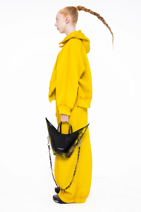 female-wearing-yellow-hoodie-with-spray-paint-with-loose-yellow-lounge-pants-on-white-background-full-body-side