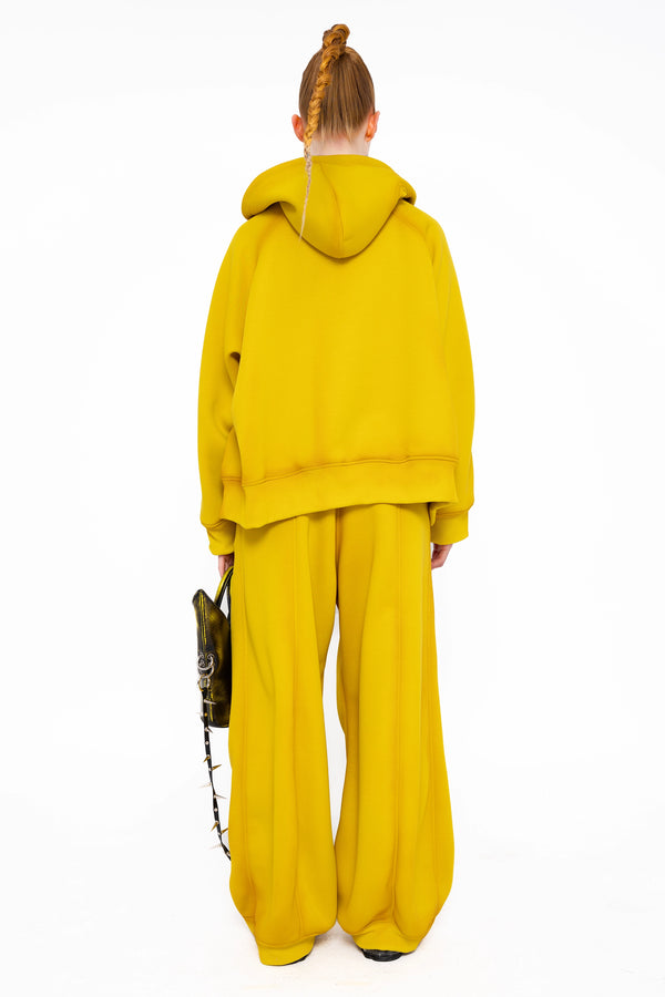 female-wearing-yellow-hoodie-with-spray-paint-with-loose-yellow-lounge-pants-on-white-background-full-body-back