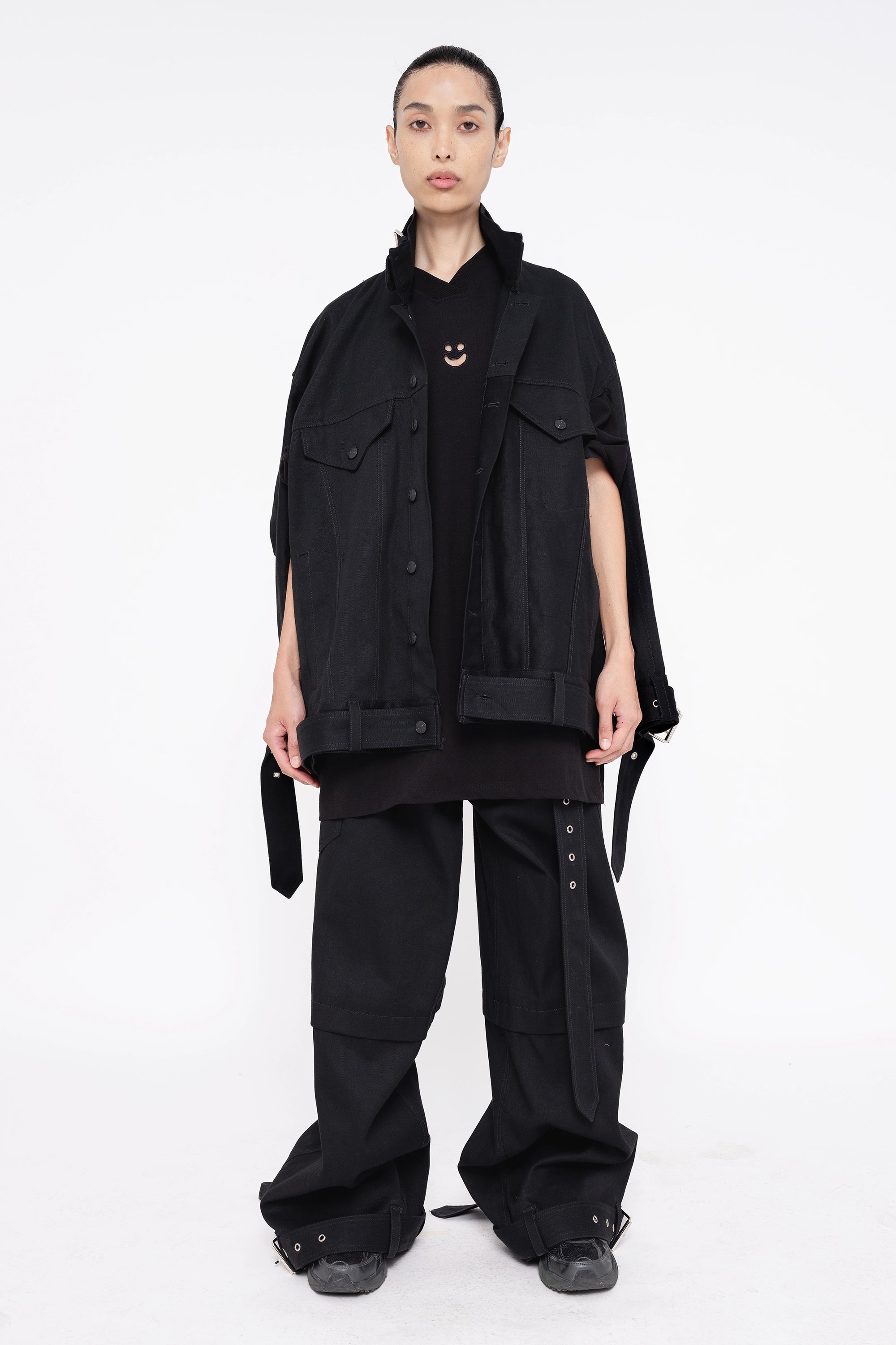 female-wearing-black-smiley-tee-and-black-denim-jacket-on-white-background-full-body-front