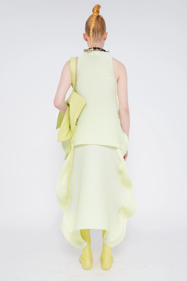 blonde-model-white-background-wearing-soft-yellow-ripple-skirt-with-matching-top-spikey-black-necklace-slouchy-soft-yellow-bag-and-soft-yellow-boots-with-soft-yellow-slouch-bag-full-body-back