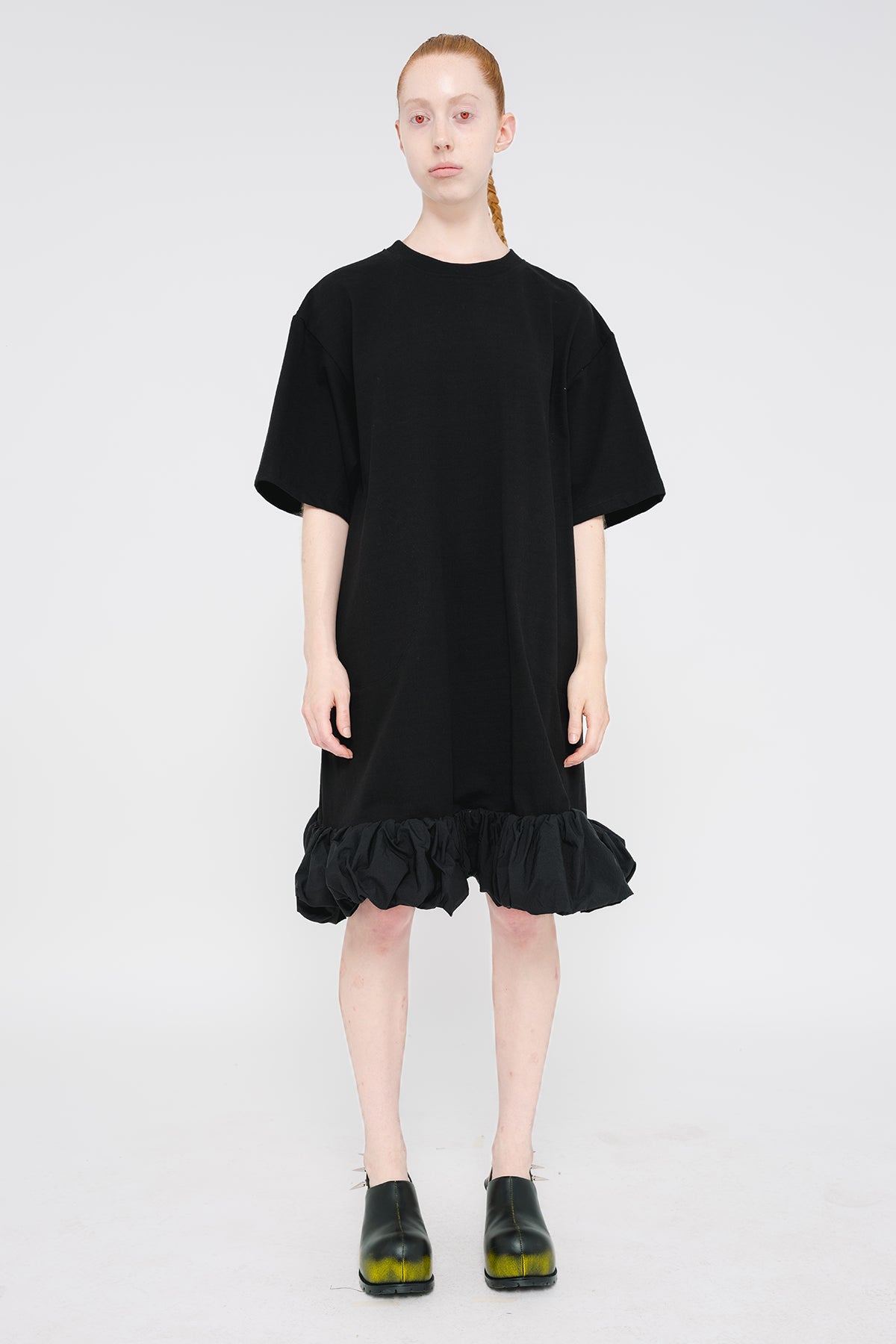 PERSON-WEARING-BLACK-TEE-DRESS-WITH-PUFFED-BOTTOM-EDGE-WITH-SPIKED-DOUBLE-HEEL-MULES-IN-PAINTED-BLACK-FRONT-VIEW