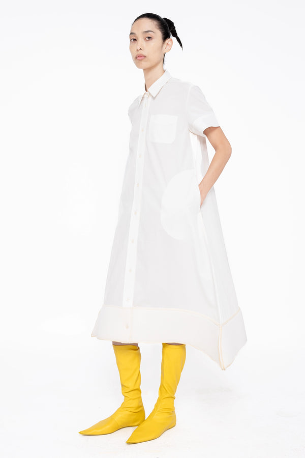 female-wearing-white-shirt-dress-with-pointy-hem-on-white-background-full-body-three-quarter