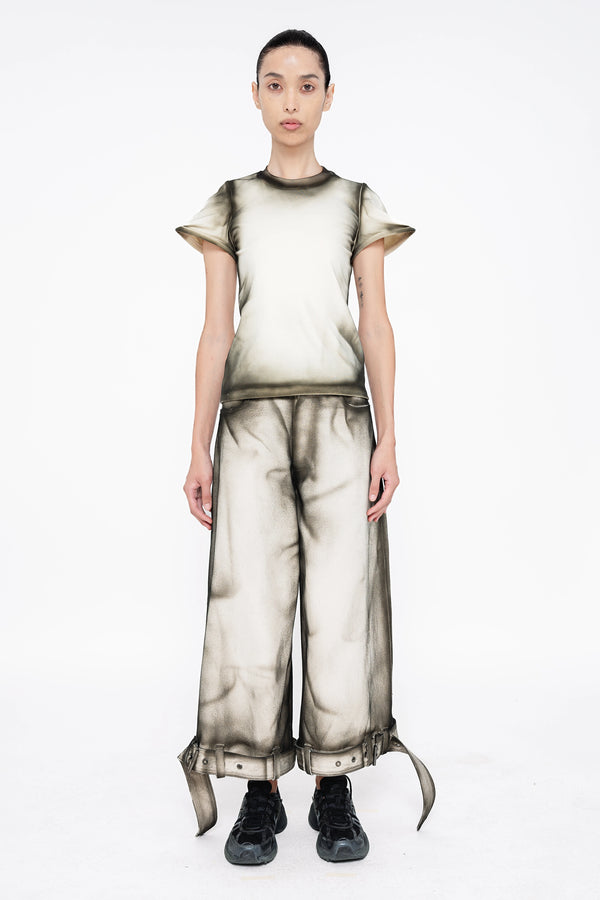 female-wearing-white-baby-tee-and-white-denim-pants-with-black-spray-paint-details-onwhite-background-full-body-front