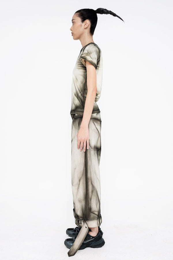female-wearing-white-tee-and-white-cropped-denim-pants-with-black-spray-paint-on-white-background-full-body-side