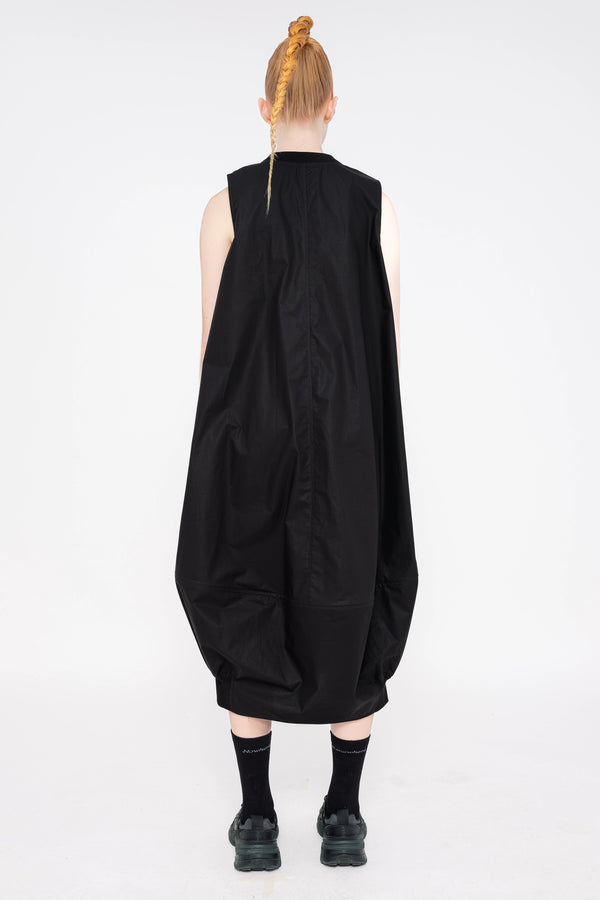 PERSON-WEARING-BLACK-SLEEVELESS-O-LINE-DRESS-WITH-FRONT-POCKETS-WITH-ATHLETIC-SNEAKERS-BACK-VIEW