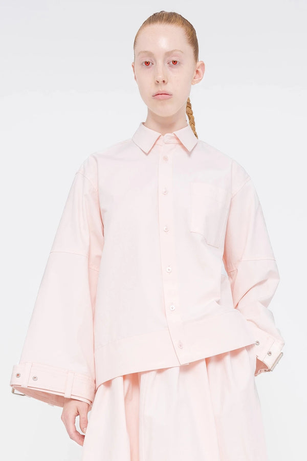 blonde-model-red-eyes-white-background-wearing-soft-pick-shirt-with-belted-sleeve-detail-quarter-view-front