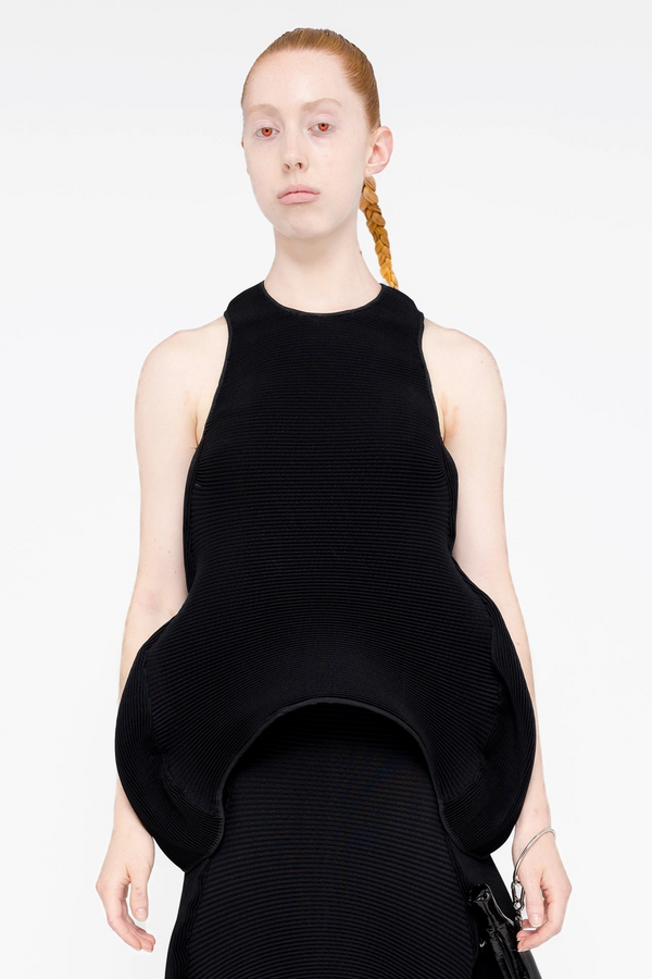 PERSON-WEARING-BLACK-PLEATED-TOP-WITH-WAVY-SHAPE-AND-MATCHING-SKIRT-CLOSE-UP-FRONT-VIEW
