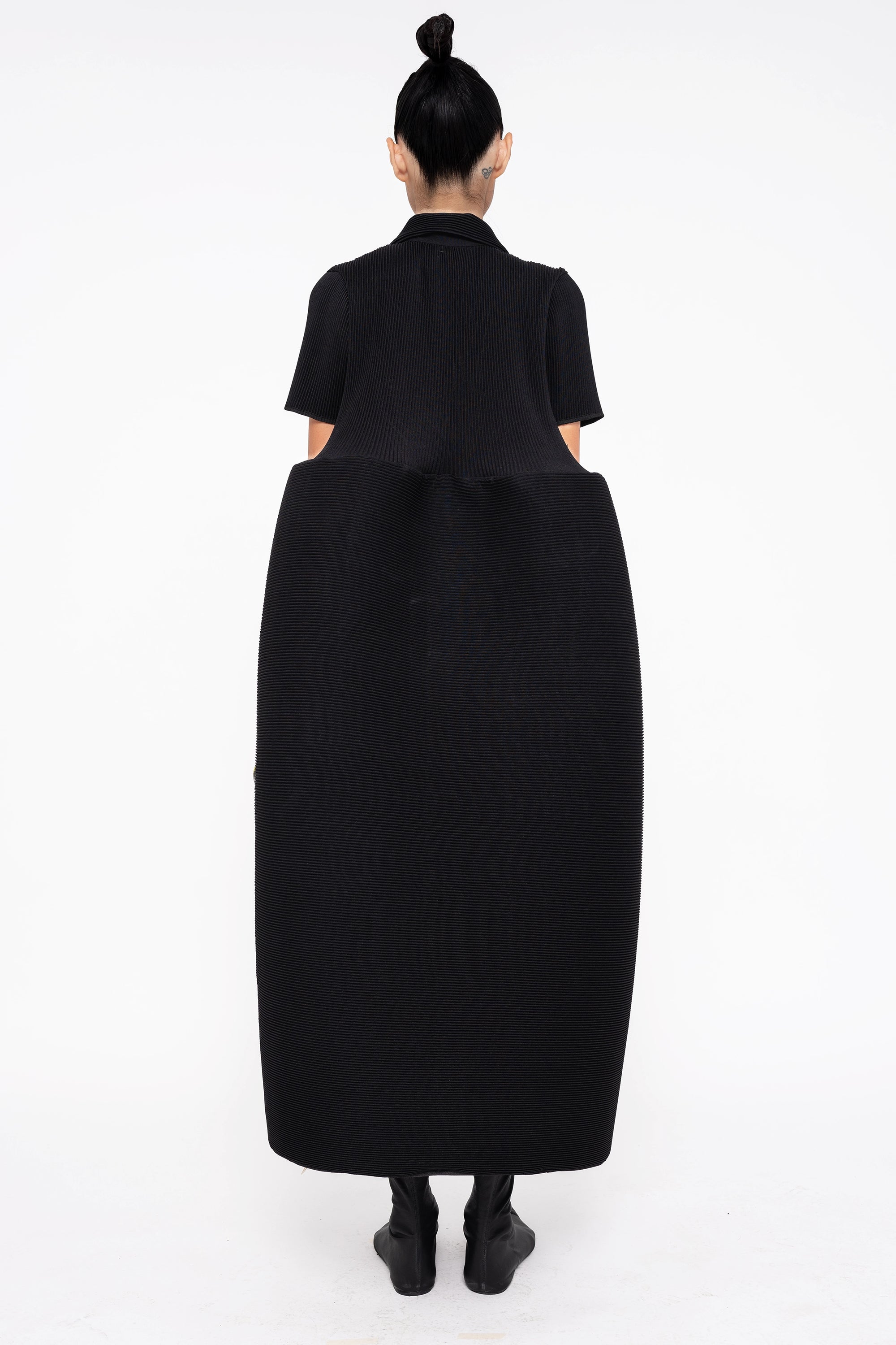 female-wearing-black-pleated-dress-with-polo-collar-and-ruffled-skirt-on-white-background-full-body-back