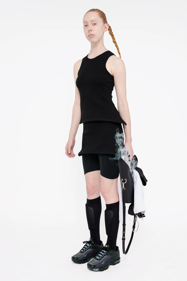 female-wearing-black-tank-top-with-pointy-hem-with-black-mini-skirt-with-point-hem-on-white-background-full-body-three-quarter
