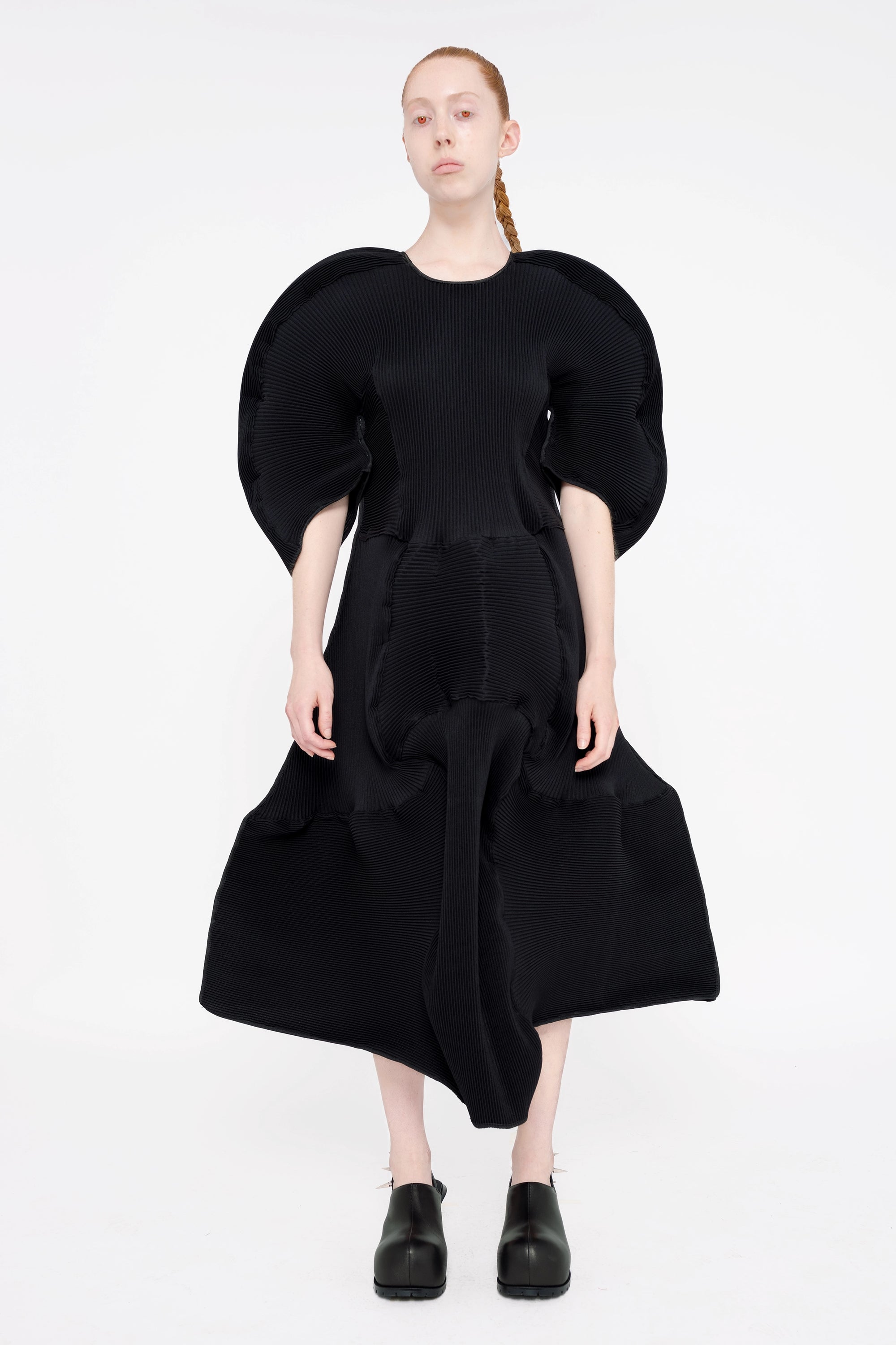 blonde-model-white-background-wearing-big-sleeve-ripple-midi-length-dress-with-black-spikey-double-heeled-mules-full-body-front-red-eyes