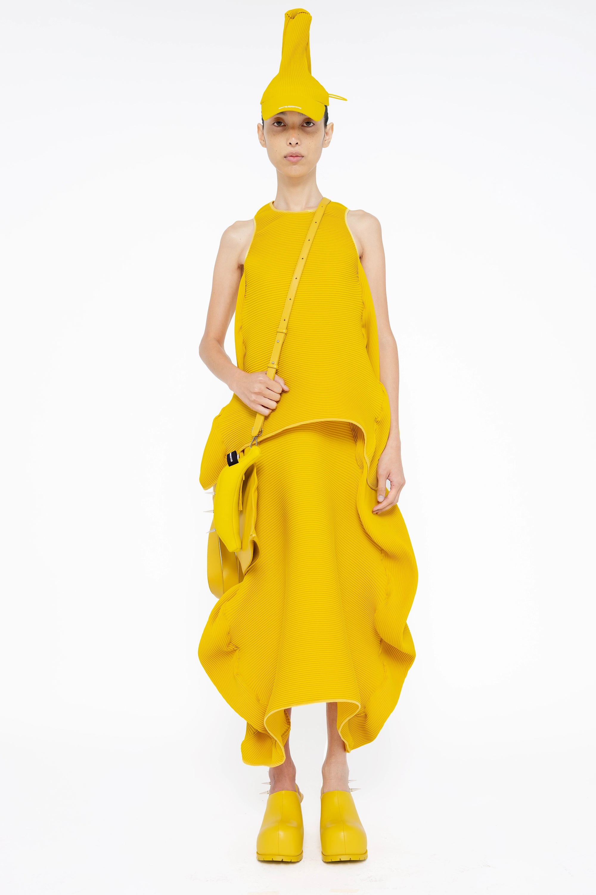 female-wearing-yellow-pleated-top-with-ruffles-and-yellow-long-pleated-skirt-with-ruffles-on-white-background-full-body-front