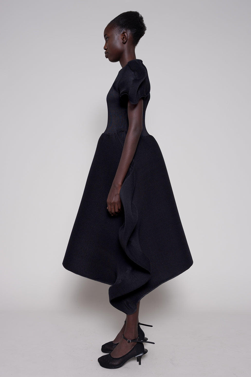 Woman wearing a black dress with a plain background