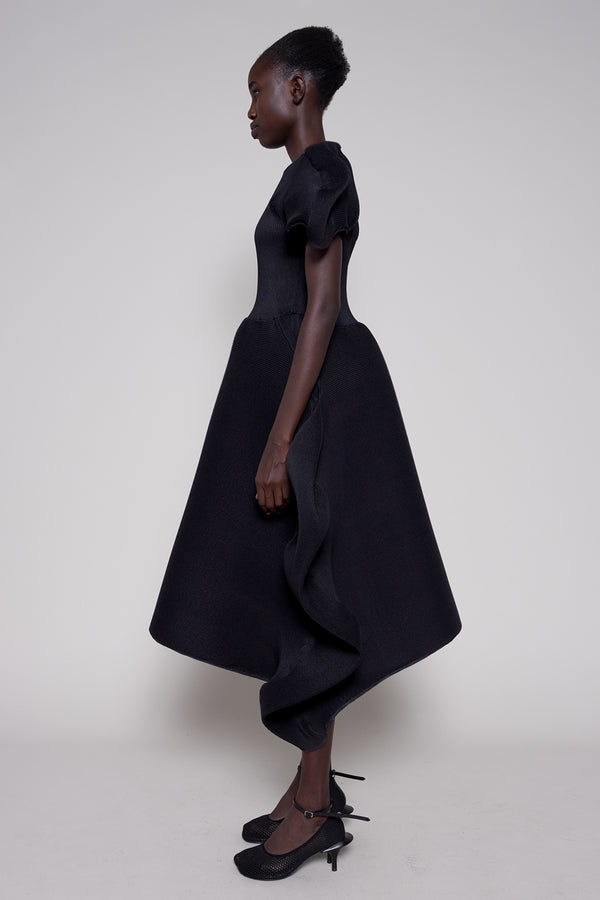 Woman wearing a black dress with a plain background