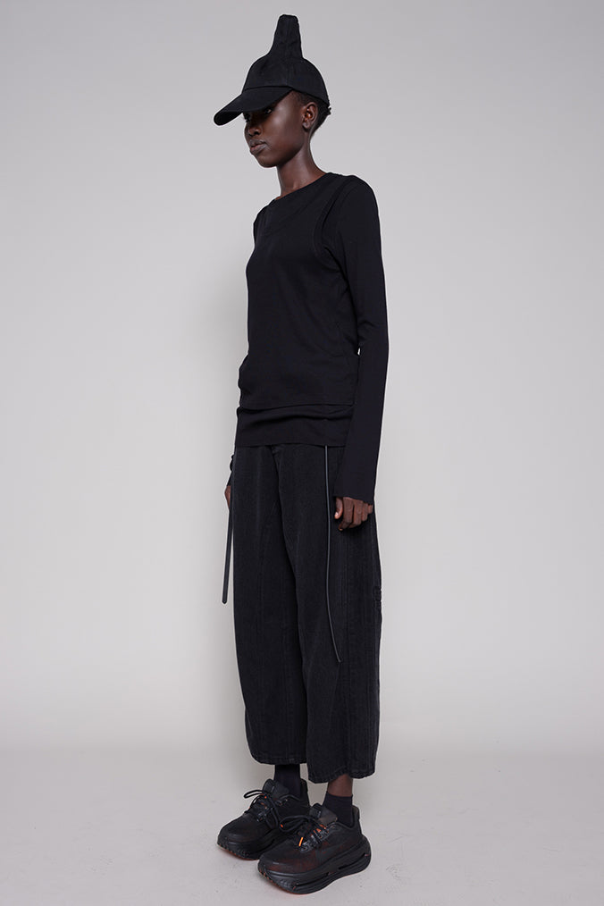 Person wearing a black outfit with a cap on a white background