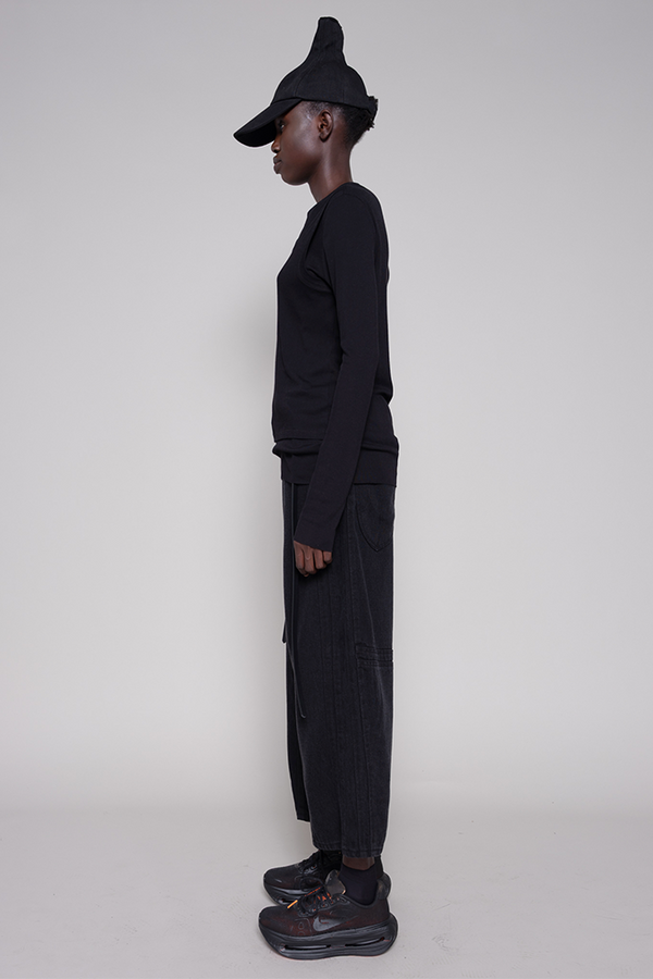 Person wearing a black outfit with a hat on a white background