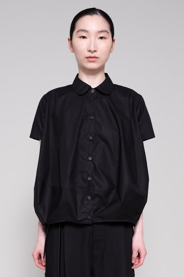 Person wearing a black shirt and pants on a plain background