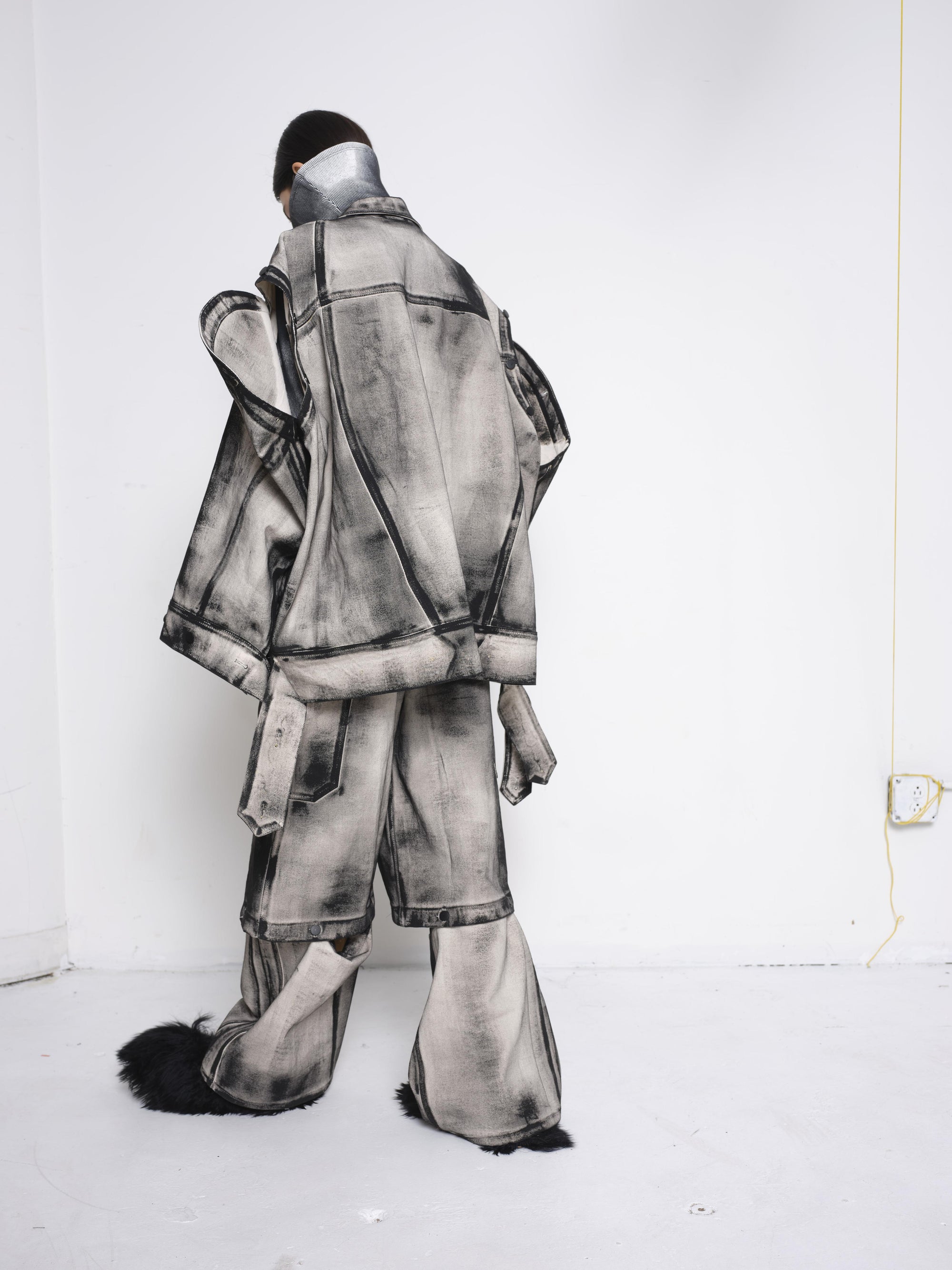 BRUNETTE-WOMAN-BACK-VIEW-FULL-BODY-WEARING-WHITE-DENIM-PAINTED-BLACK-AROUND-SEAMS-FULL-SET-OVERSIZED-DETACHABLE-ARMS-AND-LEGS